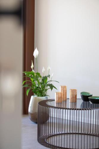 a table with a plant and a vase with candles at Ca' Allegra in Mogliano Veneto