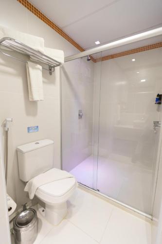 a bathroom with a shower and a toilet at Mais Hotel Aeroporto Salvador in Lauro de Freitas