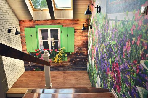 a hallway with a green door and flowers on the wall at Ostoja Wigierski in Mikolajewo