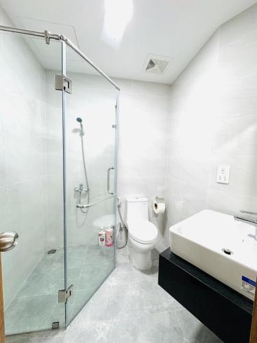 a bathroom with a shower and a toilet and a sink at Dori House Honas in Dĩ An