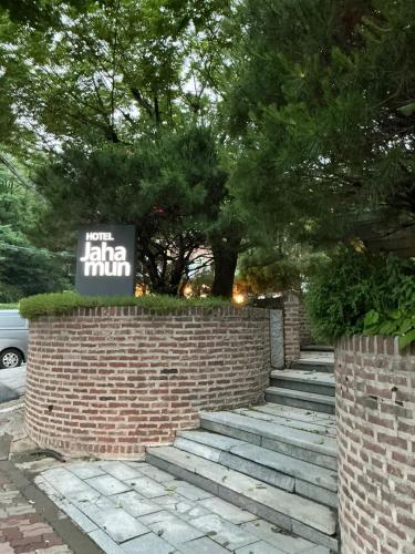 a brick wall with a sign on top of it at Jahamun Hotel in Seoul