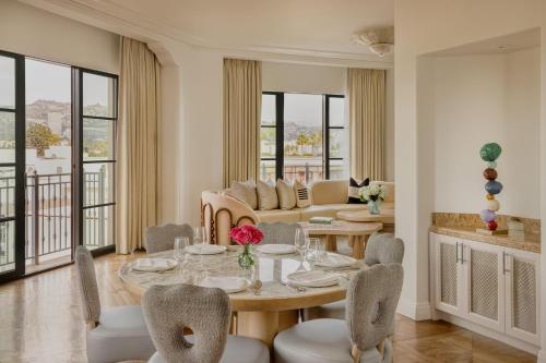 a dining room with a table and chairs and a couch at The Maybourne Beverly Hills, Maybourne in Los Angeles