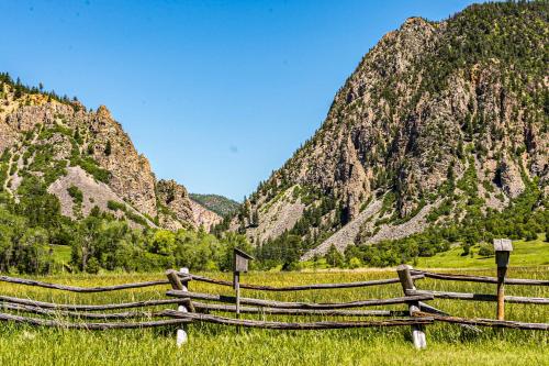 a fence in a field with mountains in the background at Elephant Mountain Cabin at Filoha Meadows in Redstone