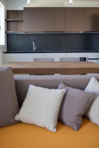 a couch with pillows in a room with a table at Ca' Allegra in Mogliano Veneto