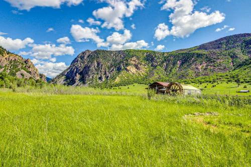 a field of green grass with a barn and mountains at Elephant Mountain Cabin at Filoha Meadows in Redstone