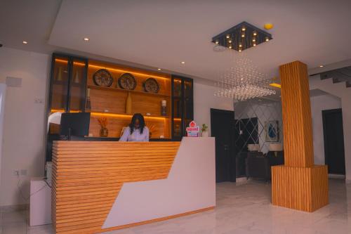 a woman standing at a counter in a restaurant at HomeWorth Hotel in Efiran