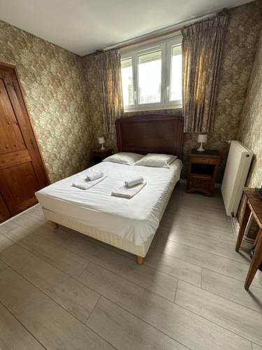 a bedroom with a large bed and a window at Hôtel Restaurant l'Annexe in Saint-Valéry-en-Caux