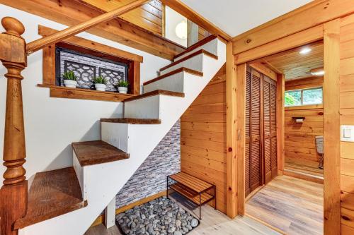 a staircase in a log home with wooden walls and wooden floors at 10 Mi to Newfoundland Lake Updated Forest Retreat 