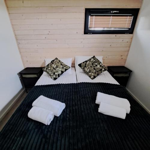 a bedroom with a bed with two pillows on it at Domki Wilków z widokiem na Łysicę in Wilków