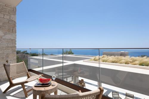 a balcony with two chairs and a table with a bowl of water at Seanatra Luxury Villas in Ferma