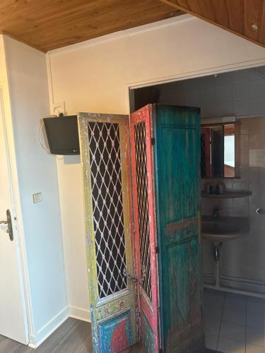 an old door in a room with a sink at Hôtel Restaurant l'Annexe in Saint-Valéry-en-Caux