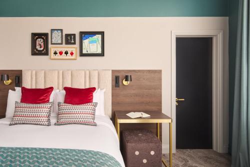 a bedroom with a bed with red pillows and a table at Hotel Indigo Leeds by IHG in Leeds