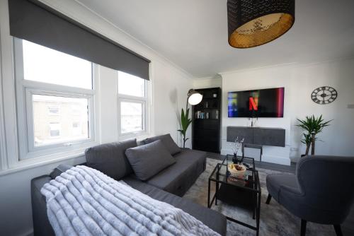 a living room with a couch and a table at 3BR Home Gem - sleeps 9 - Netflix - Near O2 & Greenwich Park in London