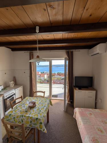 a room with a table and a kitchen with a view at Apartmani Lili in Crikvenica