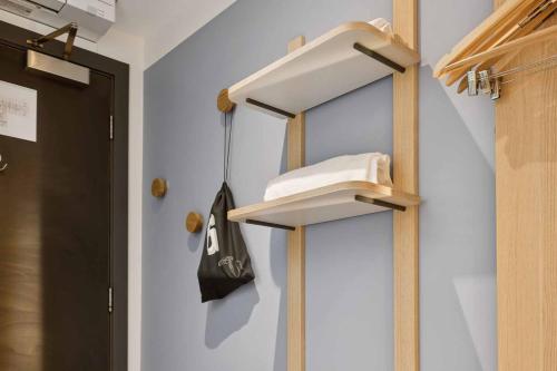 a hallway with a towel rack and a purse on a wall at Garner Hotel Edinburgh - Haymarket by IHG in Edinburgh
