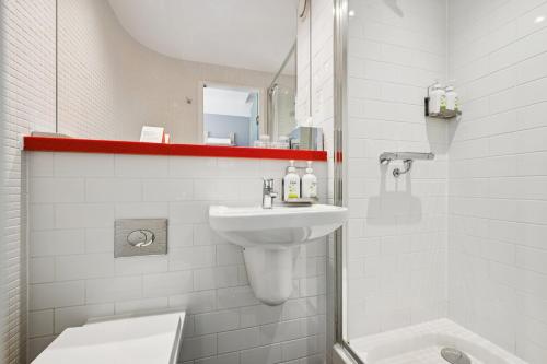 a white bathroom with a sink and a shower at Garner Hotel Edinburgh - Haymarket by IHG in Edinburgh