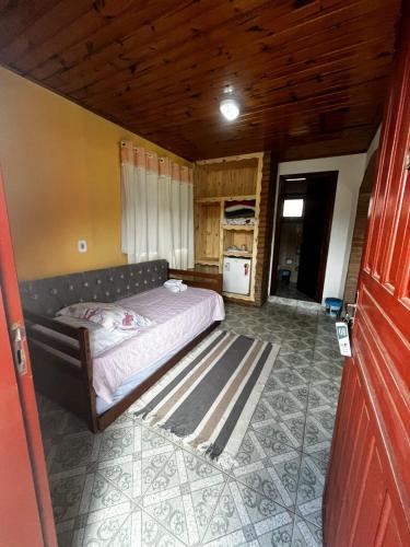 a bedroom with a bed and a wooden ceiling at Pousada Cantinho Colibri in Monte Verde