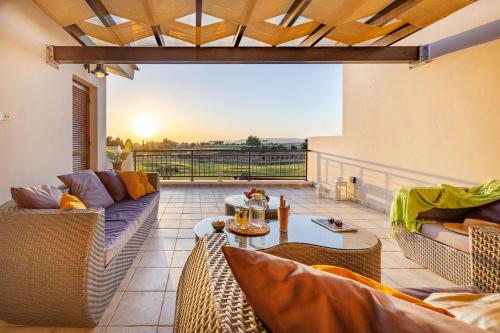 a living room with couches and a table on a balcony at HG07 Adjacent to Aphrodite Hills- Private Pool, Large Terrace in Kouklia