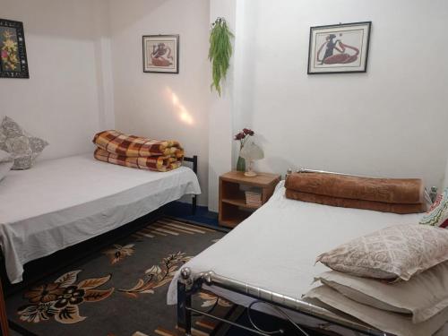 a room with two beds and a table at Bini's Homestay in Mirik