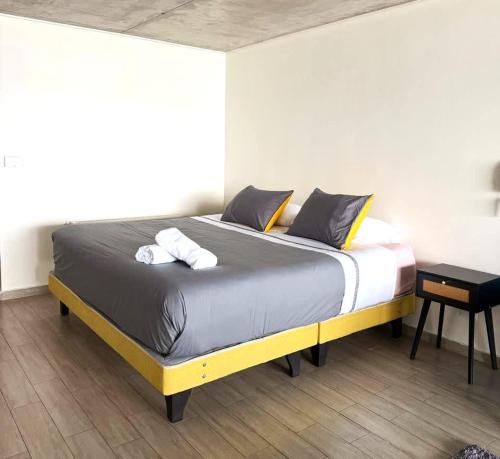 Un dormitorio con una cama con dos toallas encima. en HOM l Estudio con Vista al mar 3PAX, en Valparaíso