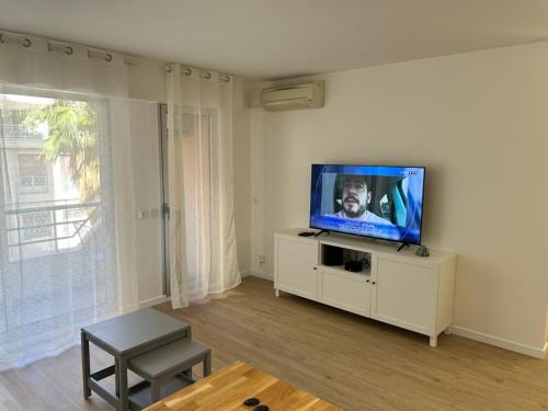 un salon avec une télévision à écran plat sur un meuble blanc dans l'établissement Studio rue de France, à Nice