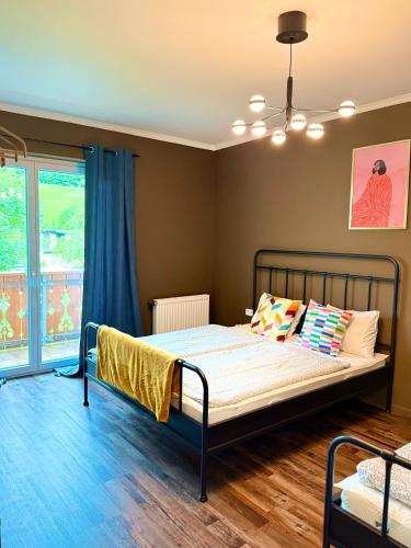 a bedroom with a bed and a large window at MiHome - Grimming View Apartment in Tauplitz