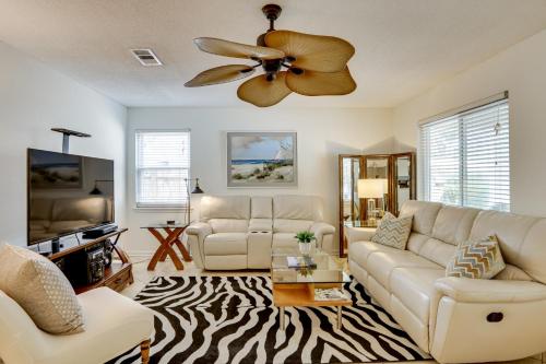 a living room with a couch and a ceiling fan at Centrally Located St Simons Island Getaway! in Ebo Landing