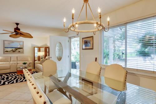 a dining room with a glass table and chairs at Centrally Located St Simons Island Getaway! in Ebo Landing