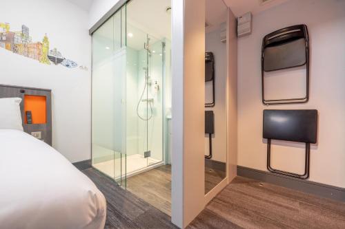 a bedroom with a glass shower and a bed at easyHotel Belfast in Belfast