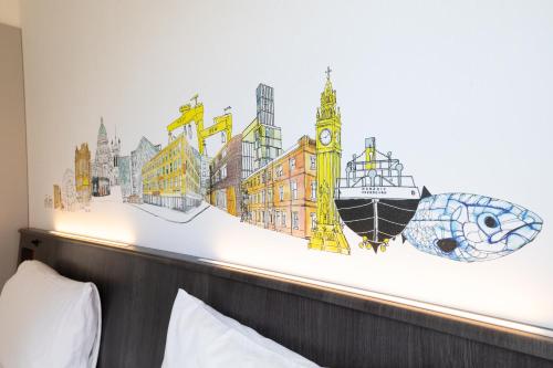a bedroom with a wall mural of a city at easyHotel Belfast in Belfast