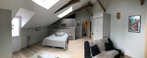 Cette chambre mansardée comprend un lit et un canapé. dans l'établissement Domaine de Grisere chambre 1, à Tilh