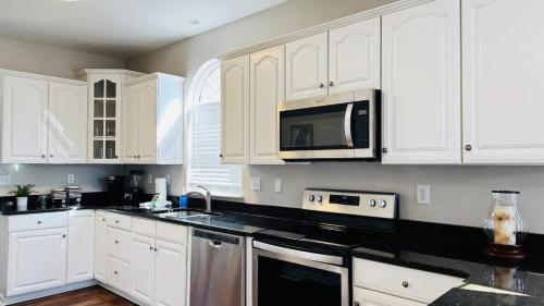 a kitchen with white cabinets and black counter tops at Beautiful duplex in Murrells Inlet B in Myrtle Beach