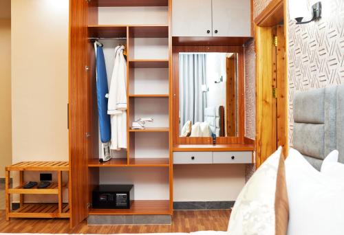 a dressing room with a mirror and a bed at Tha Nickolee Hotel in Nanyuki