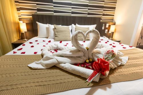 two swans made out of towels on a bed at Mais Hotel Aeroporto Salvador in Lauro de Freitas