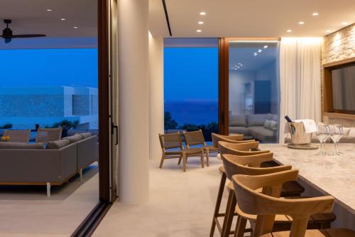 a living room with a bar and chairs at Seanatra Luxury Villas in Ferma