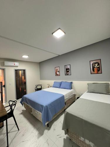 a bedroom with two beds and a table and chairs at Hotel Acqua Park in Capim Grosso