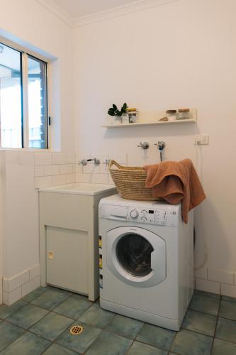 a laundry room with a washing machine and a sink at Cool beachside apartment on Jetty Road Brighton in Brighton