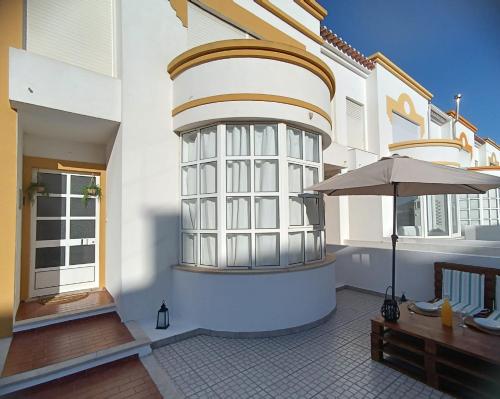 a white building with an umbrella on a patio at Bal&Bal in Ferrel