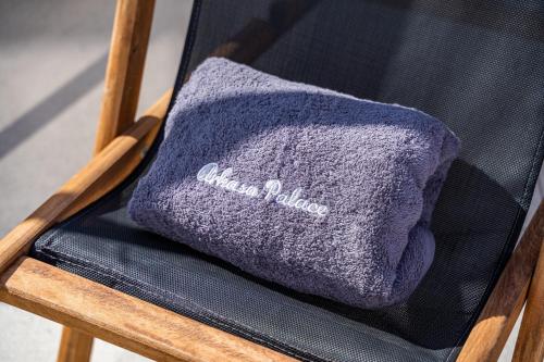 a purple towel sitting on a wooden chair at Arkasa Palace in Arkasa