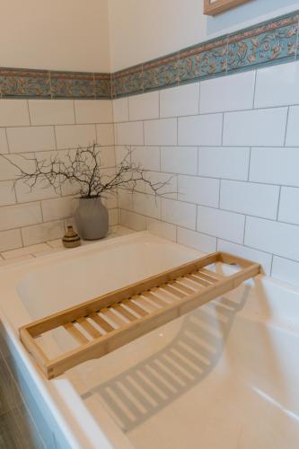 a bath tub with a vase sitting on top of it at Cool beachside apartment on Jetty Road Brighton in Brighton