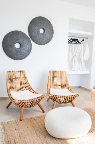 two rattan chairs and a white ottoman in a room at Arkasa Palace in Arkasa