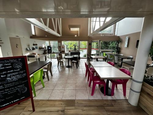 a restaurant with tables and chairs in a room at Hôtel L'ile Du Saussay in Itteville