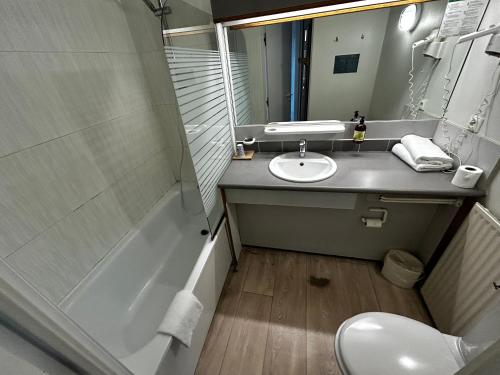 a bathroom with a sink and a toilet and a tub at Hôtel L'ile Du Saussay in Itteville