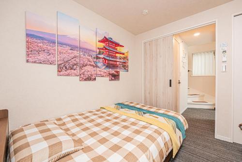 a bedroom with a bed and some paintings on the wall at Private 3 Bedroom House with Free Parking Near Asakusa and Skytree in Tokyo