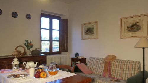 a living room with a table and a couch at Agriturismo I Moricci in Peccioli
