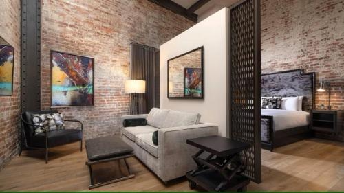 a bedroom with a bed and a couch and a mirror at JW Marriott Savannah Plant Riverside District in Savannah