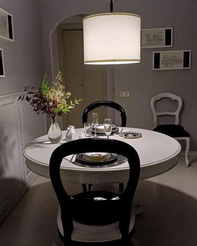 a dining room table with a vase of flowers on it at Le Jardin Secret in Milan