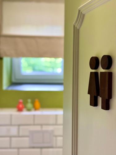 a bathroom door with a sign of two men on it at MiHome - Grimming View Apartment in Tauplitz