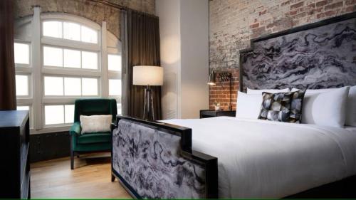 a bedroom with a large bed and a brick wall at JW Marriott Savannah Plant Riverside District in Savannah