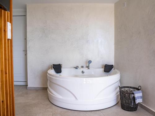 a white tub in a bathroom with a sink at Arkasa Palace in Arkasa